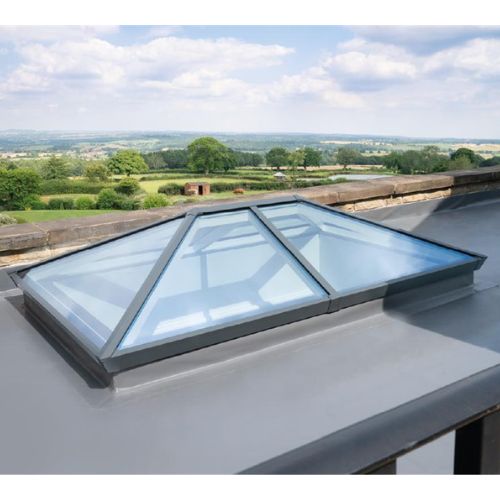 Skylight on a roof with a scenic view of trees and fields.
