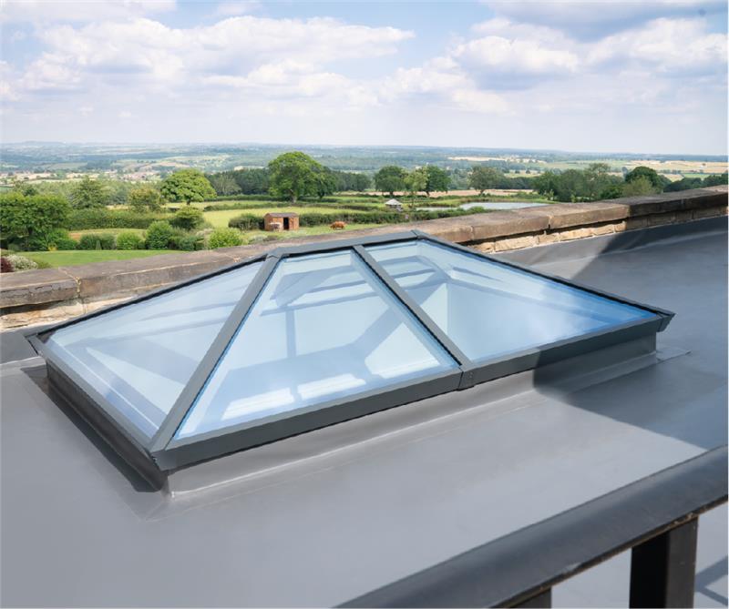 Skylight on a roof with a scenic view of trees and fields below